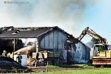 18-10-2022 Prinsenbeek - Om bij de brandhaard te kunnen komen is met een graafmachine de zijkant van de schuur gesloopt. - Fotokrant