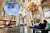 19-01-2022 Breda - Vanwege het cultuurprotest ging ondanks dat deze gesloten moet zijn de Grote of Onze Lieve Vrouwekerk voor 1 dag open. Mensen mochten na het scannen van de QR code en met een mondkapje op gratis de expositie Museum of the Moon bezoeken. De gigantische maan die in de kerk hangt is van de Engelse kunstenaar Luke Jerram. - Fotokrant