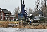 20-12-2023 Breda - Aan de oevers van rivier De Mark voeren bouwers de strijd tegen het stijgende water van de rivier.Langs de oevers worden damwanden geslaan om de woningen te beschermen tegen het water. - Fotokrant
