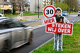 10-04-2026 Breda -  Na de herinrichting van De Heerbaan zijn bij de school de zebrapaden en stoplichten verdwenen. Inmiddels staan er al een tijdje foto's van kinderen met een 30 KM bord in hun hand.  - Fotokrant