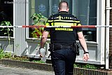19-08-2019 Breda - Een agent komt met een koker naar het huis . In dergelijke kokers vervoerd de recherche gevonden steekwapens. - Fotokrant