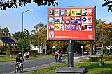 02-10-2025 Ulvenhout - In het kerkdorp staat het verkiezingsbord voor de Tweede Kamerverkiezingen alweer te schitteren in de zon. - Fotokrant