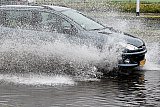 04-07-2021 Breda - Een auto rijd tijdens de enorme wolkbreuk door het water. - Fotokrant