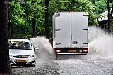 19-06-2019 Bavel - Code Oranje . Hoge golven regenwater spatten op als er een vrachtwagen door een ondergelopen straat rijd. - Fotokrant