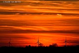 16-04-2022 Breda - Windmolens aan de horizon tijdens de oranje zonsondergang. Door de vraag naar meer energie zullen er veel meer en grotere windmolens bij gaan komen. - Fotokrant
